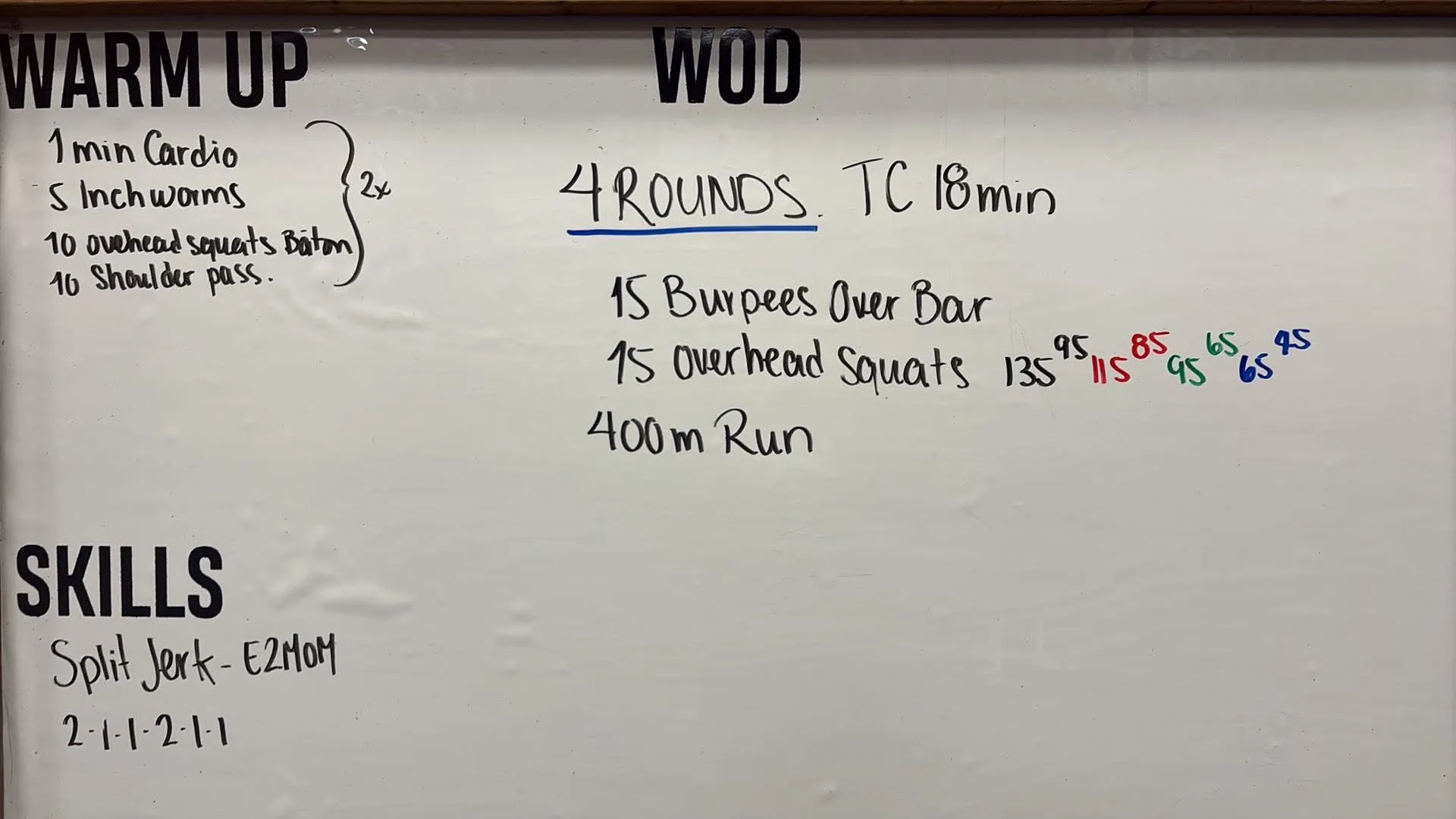 Tableau blanc du WOD chez CrossFit Chicoutimi : warm up en deux tours, skills split jerk en E2MOM, pis un WOD de 4 rounds avec burpees over bar, overhead squats à quatre niveaux de charge en couleurs (le rouge étant le Rx) et course de 400 m